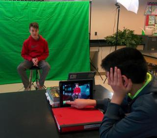 JGMS students creating a video using green screen technology.