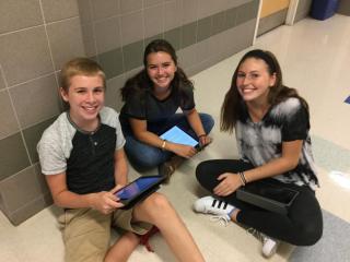 High School students working collaboratively with iPads to complete class assignments.
