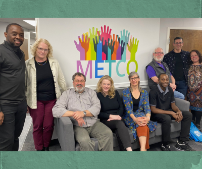 group of people standing in front of a METCO logo