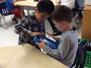 Davis students working collaboratively using an iPad.