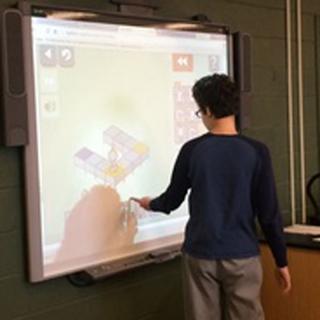 JGMS student demonstrating his solution to a coding problem.
